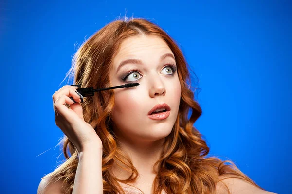 Mujer joven aplicando maquillaje — Foto de Stock