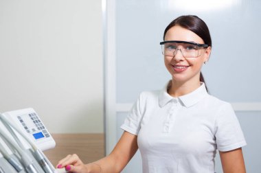 Tıbbi ofis arka plan üzerinde mutlu genç kadın diş hekimi