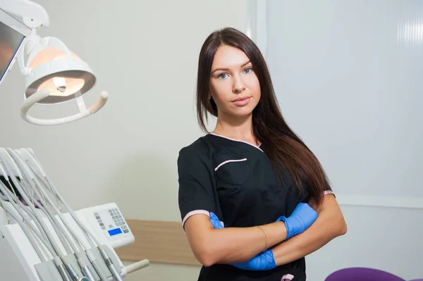 Gelukkig jonge vrouwelijke tandarts over medische kantoor achtergrond — Stockfoto