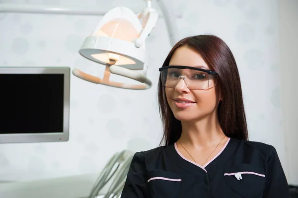 Jovem dentista feliz sobre o fundo do consultório médico — Fotografia de Stock