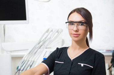 Tıbbi ofis arka plan üzerinde mutlu genç kadın diş hekimi