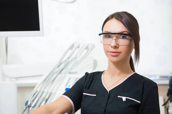 Boldog fiatal női fogorvos orvosi rendelő háttér felett — Stock Fotó