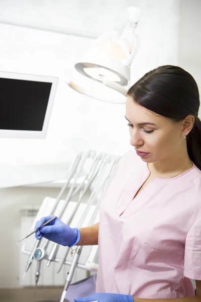 Happy young female dentist over medical office background