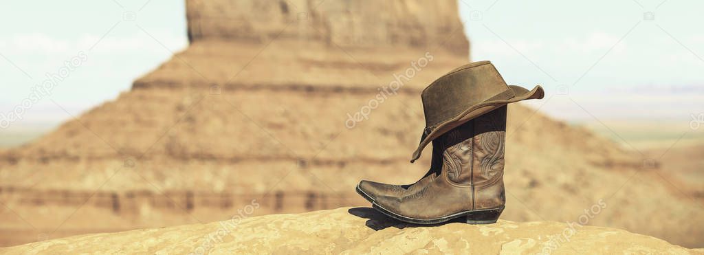 Boots and hat in front of Monument Valley