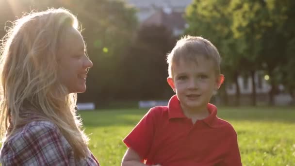 Happy mom and her little child kiss at the sunset — Stock Video