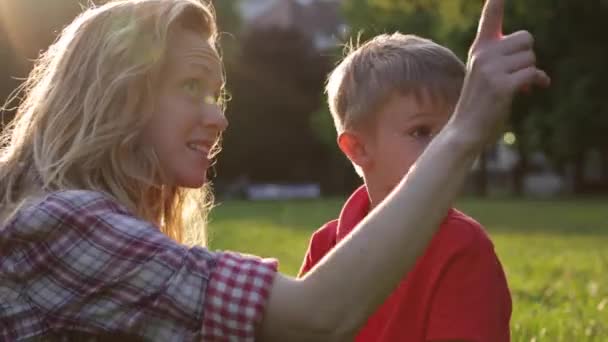 Счастливая мама покажет что-нибудь своему любопытному сыну — стоковое видео