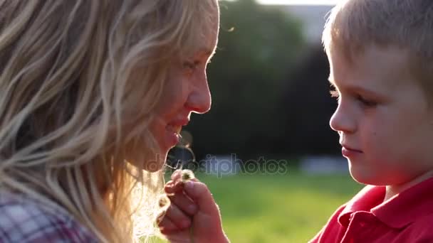 Счастливая мама целует своего ребенка на закате — стоковое видео