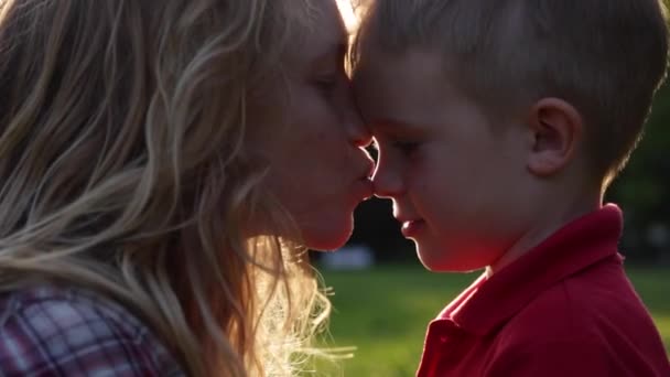 Feliz besar a mamá y al niño al atardecer — Vídeo de stock