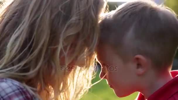 Câlin maman heureuse et enfant jouent sur le coucher du soleil — Video