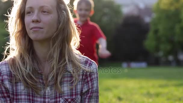 Bonne maman et son enfant s'amusent au coucher du soleil — Video