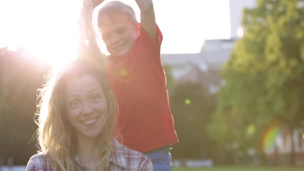Boldog anya és aranyos gyermek jó szórakozást a naplemente — Stock videók