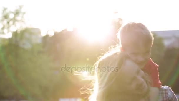Mãe feliz e criança brincam no pôr do sol no parque — Vídeo de Stock