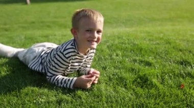 Çim üzerinde yalan şirin güzel mutlu küçük boy gülümseyerek