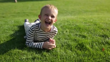 Parlak çim üzerinde yalan şirin güzel mutlu küçük boy gülümseyerek