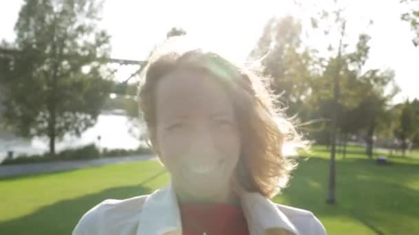 Giovane donna bella felice con i capelli biondi ricci sorriso, vento che soffia — Video Stock