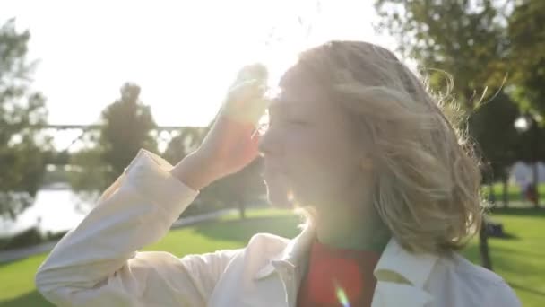 Jonge gelukkig mooie vrouw met blond krullend haar dromen, de wind waait — Stockvideo