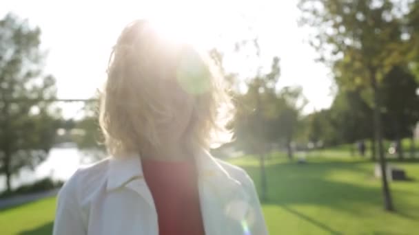 Junge glückliche schöne Frau mit blonden lockigen Haaren lachend, Wind weht — Stockvideo