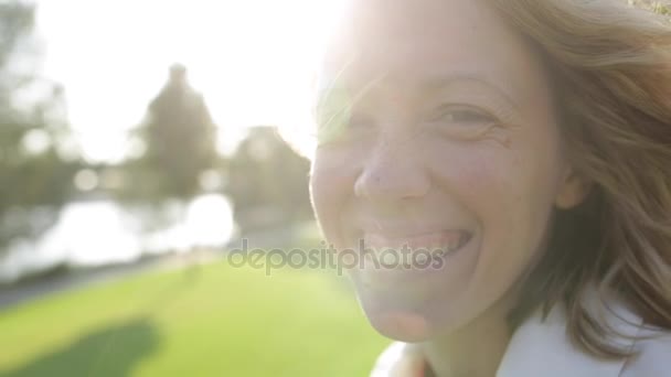 Jovem mulher bonita feliz com cabelo encaracolado loira sorrindo, vento soprando — Vídeo de Stock