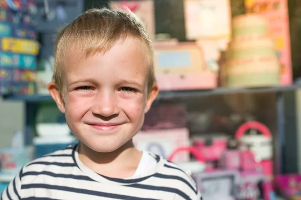 Bonito menino feliz bonito sorrindo na frente da vitrine — Fotografia de Stock