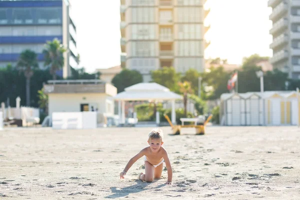 Szczęśliwy piękne dziecko grać na piasku plaży, patrząc na kamery — Zdjęcie stockowe