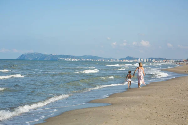 Gelukkig mooi moeder en kind wandelen langs het strand zee, kopie-ruimte — Stockfoto