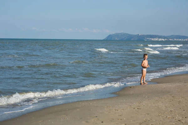 Szczęśliwy uśmiechający się chłopczyk cieszyć się latem na plaży Morza — Zdjęcie stockowe