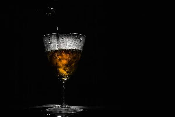 Vin savoureux versé dans un beau verre vintage brouillard, fond noir — Photo