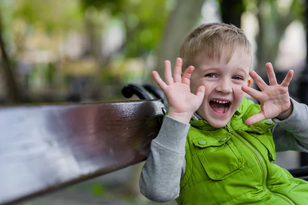 Nadšený šťastný malý blonďák s otevřenou rukou nahoru podívat na kameru — Stock fotografie