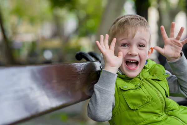 Excited happy little blonde boy with wow open hands looking at camera — Stock Photo, Image