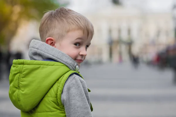 Invitando curioso niño hermoso mirando a la cámara, medio giro — Foto de Stock