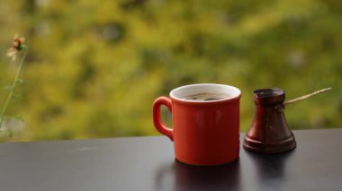 Geleneksel Türk kahvesi tencerede, Cafe tablo açık havada sıcak kırmızı Kupası'nda lezzetli dumanı tüten kahve demlendi