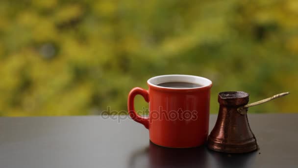 Heta välsmakande ångande drink i röd kopp bryggs i traditionella turkiska kaffekanna, café bord utomhus — Stockvideo