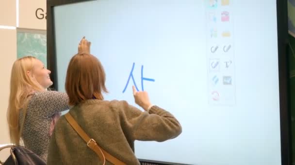 Девушка рисует пальцем через монитор. на огромных мониторных линиях — стоковое видео