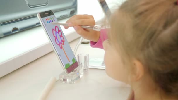 Menina pinta uma flor na tela do telefone, mantém as mãos Stylus — Vídeo de Stock