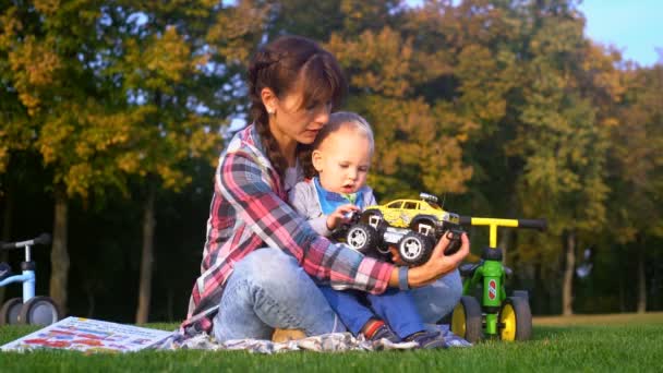 Máma ukazuje své dítě že novou hračku je žlutá Jeep — Stock video