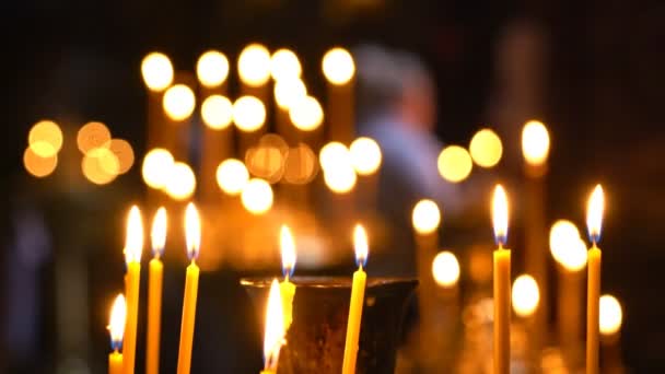 In der orthodoxen Kirche brennen Kerzen Menschen kommen, um eine Kerze anzuzünden — Stockvideo