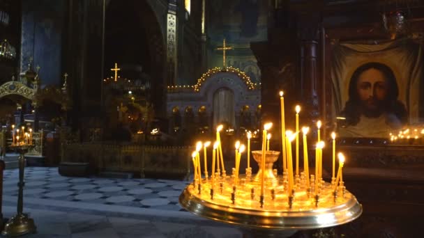 Kerzen brennen in der Kirche. eine leere Halle und Stille. das Symbol an der Wand mit dem Bild Christi — Stockvideo
