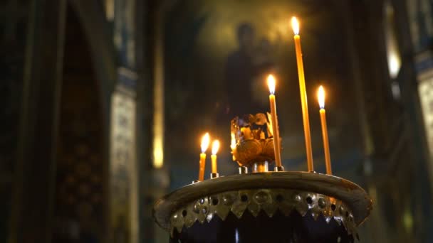 기독교 교회에 촛불 켜 집니다. 우울한 분위기와 벽에 성도의 이미지와 대성당의 천장. — 비디오
