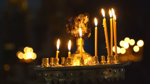 Свечи горят в церкви. на заднем плане, свечи вне фокуса Мягкий Bokeh — стоковое видео