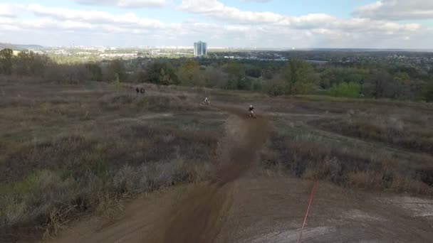 Dos jinetes de Motocross montando en la pista todoterreno. Drone vuela delante de ellos llevando la cámara — Vídeo de stock