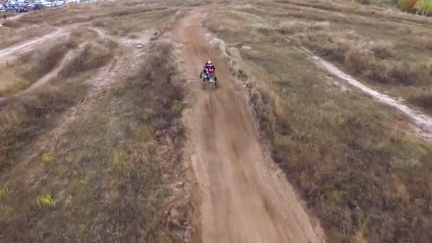 Drönare och kamera förföljer Rider på en Atv. Fyrhjuling som hoppar på studsmatta och Reserve moln av damm och smuts. — Stockvideo