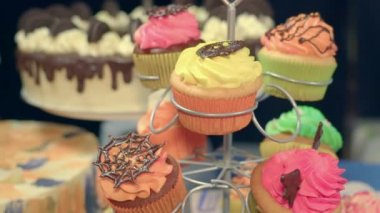 Tatlı kek ve lezzetli hamur işleri, çikolata topları ve renkli tatlılar. Pişirme masa etrafında kamera sinekler