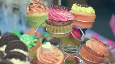 Bir pasta bir stand ve büyük bir çikolatalı pasta oluşan tatlı tablo. Tüm ürünler el emeği farklı şekil ve renk,