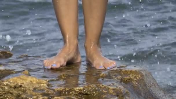Ženské nohy na kamenné moře. — Stock video