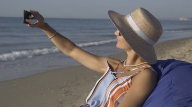 Bir kız selfie denizde yapar.