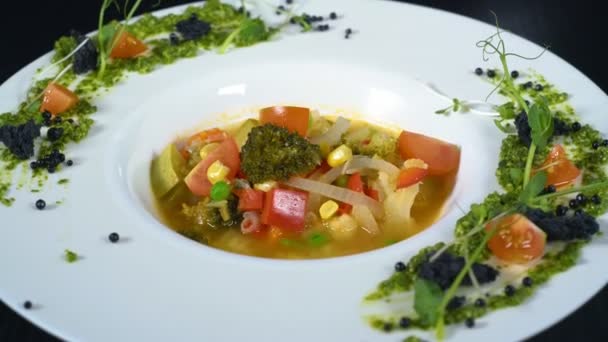 Sopa de verduras en un plato de cerámica blanca — Vídeo de stock