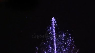Ağır çekim gece çeşme. Su jet siyah bir zemin üzerine.