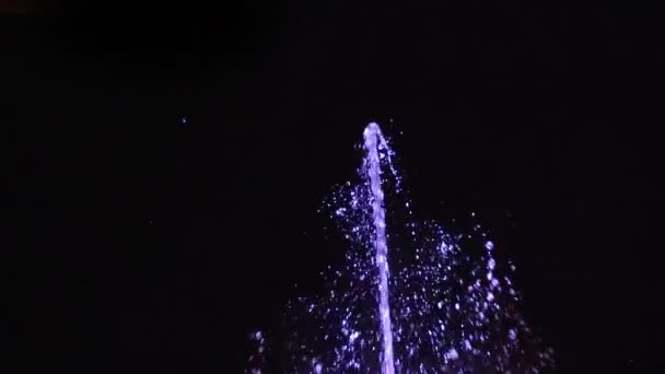 Slow-motion nacht fontein. Een straal water op een zwarte achtergrond. — Stockvideo