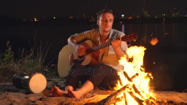 Kampvuur rond het kampvuur met een gitaar — Stockvideo