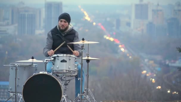 Muž si hraje drum set proti večer Kyjev — Stock video